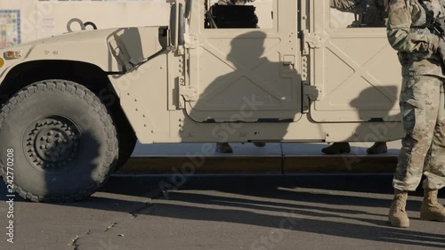 Civilians talking to soldiers next to a Humvee.