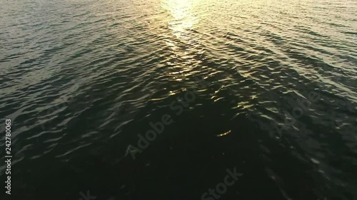 Aerial Flying Low Over Sea Water at Sunset photo