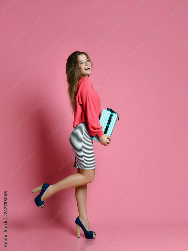 Woman walking with shopping presents gift box for happy valentines day on pink Woman walking with shopping presents gift box for happy valentines day on pink