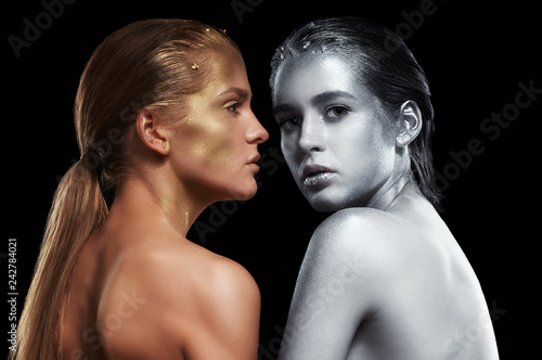 Beauty portrait of young gorgeous women. Golden and silver girls on black background