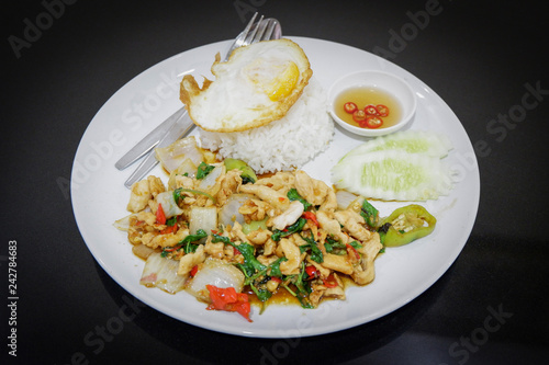 fried hot and spicy thai food stir fried holy basil chicken slice with fry an egg and cooking rice on plate