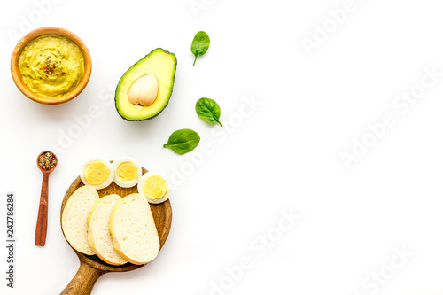 Sandwiches with avocado concept. Whole grain bread, half of avocado, guacamole on white background top view copy space