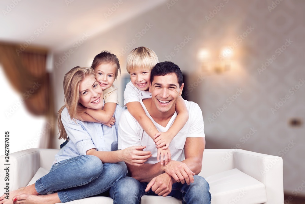 Beautiful smiling family sitting at sofa at home