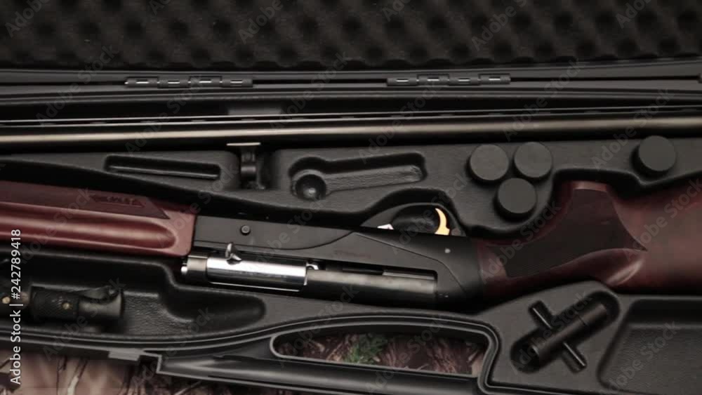 disassembled shotgun parts in the gun case on the camouflage background disassembled shotgun parts in the gun case on the camouflage background