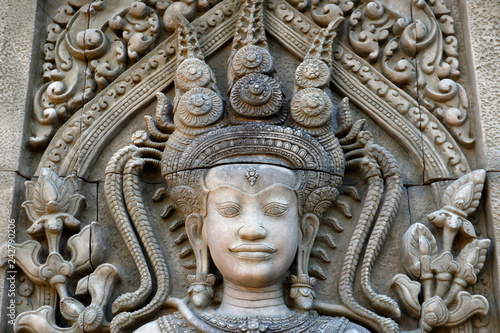 Khmer God Sandstone Statue on the Wall in the City Park photo