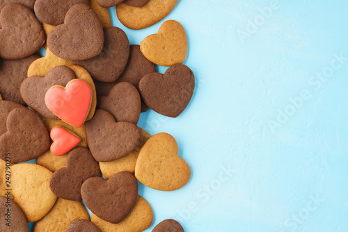 Red hearts made of glazed gingerbreads over a bunch of cookies.