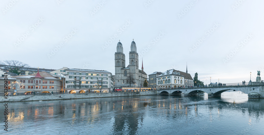 Zurich, ZH / Switzerland - January 4, 2019: many people crossing a bridge over the Limmat on their way to the Grossmuenster cathedral in Zurich Zurich, ZH / Switzerland - January 4, 2019: many people crossing a bridge over the Limmat on their way to the Grossmuenster cathedral in Zurich