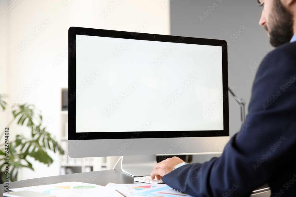 Young businessman working on computer in office Young businessman working on computer in office