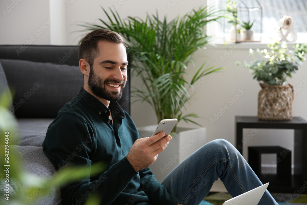 Young freelancer with mobile phone working at home Young freelancer with mobile phone working at home