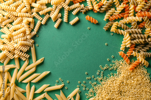 Frame made of assortment pasta on color background
