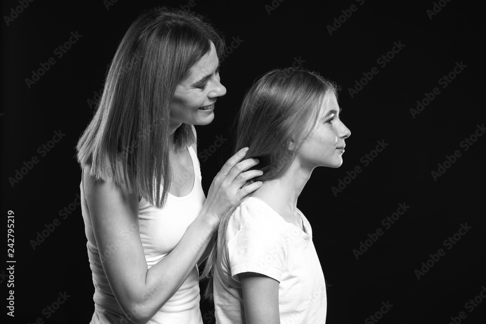 Black and white portrait of happy mother and daughter on dark background Black and white portrait of happy mother and daughter on dark background