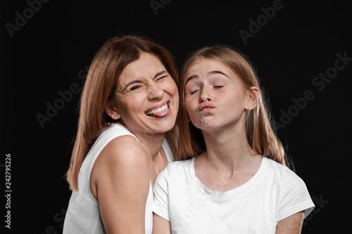 Portrait of funny mother and daughter on dark background