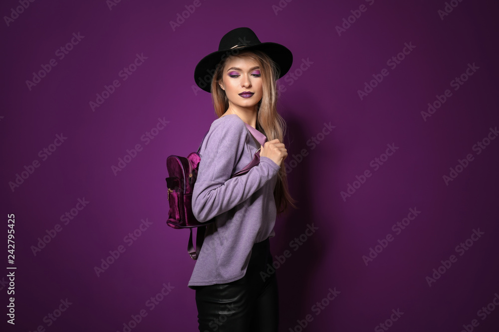 Fototapeta premium Fashionable young woman on violet background