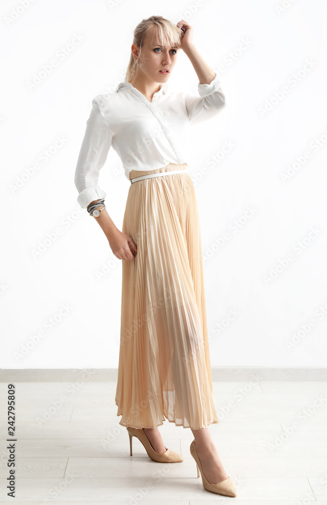 Beautiful stylish young woman near white wall Beautiful stylish young woman near white wall