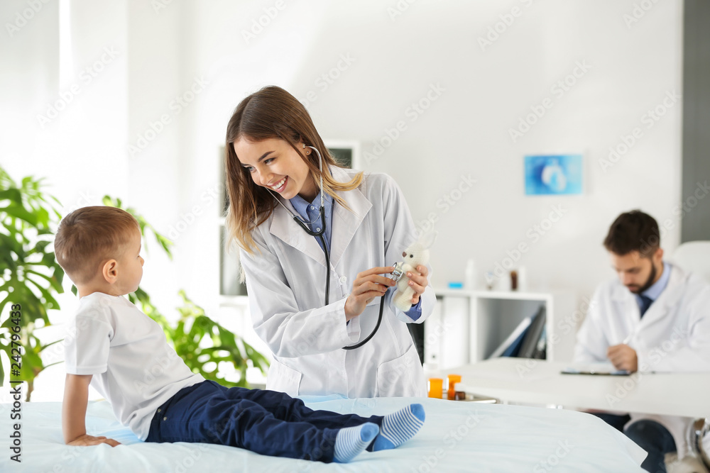 Female doctor working with cute little boy in clinic Female doctor working with cute little boy in clinic