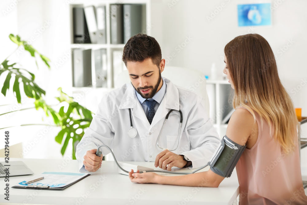Male doctor working with female patient in clinic Male doctor working with female patient in clinic
