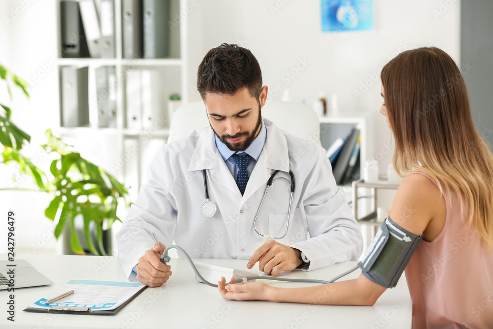 Male doctor working with female patient in clinic Male doctor working with female patient in clinic