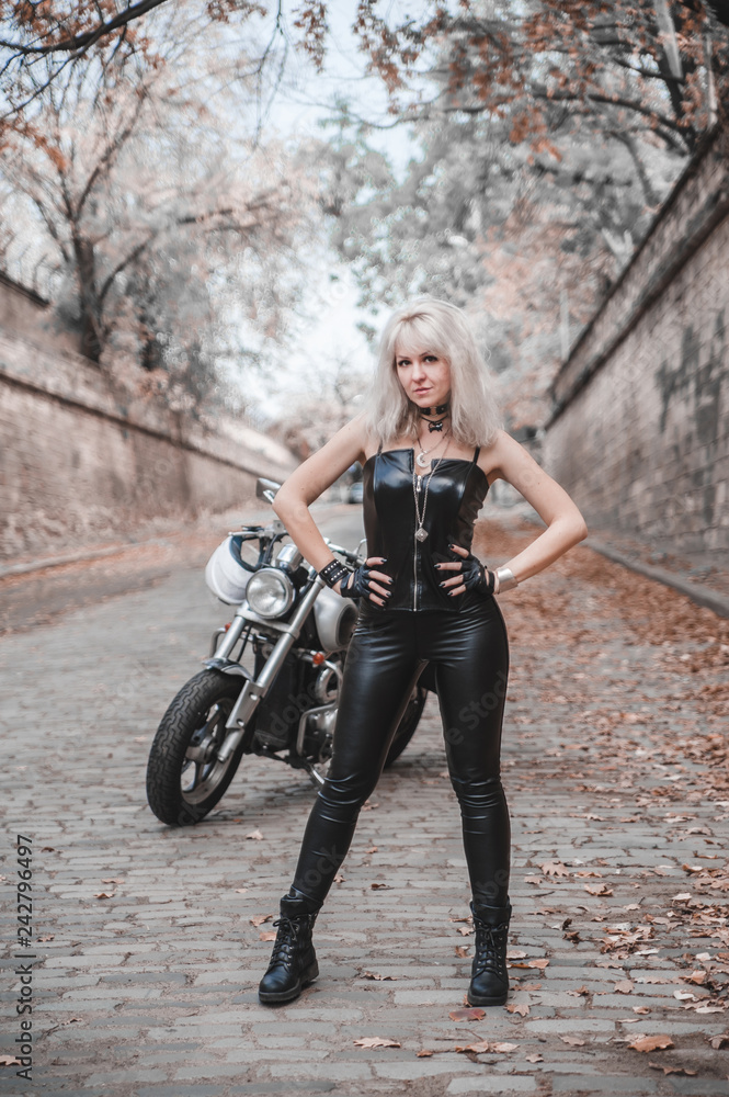 Naklejka premium Beautiful biker woman outdoor with motorcycle. 