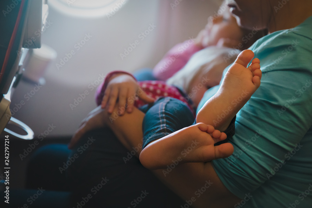 mother holding little baby on travel by plane