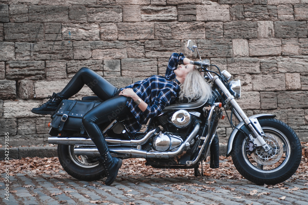 Beautiful biker woman outdoor with motorcycle.
