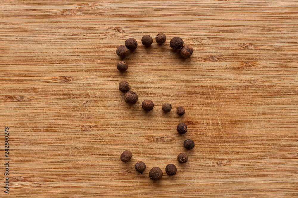 Capital characters made of peppercorns. Alphabet letters on wood background. Capital characters made of peppercorns. Alphabet letters on wood background.