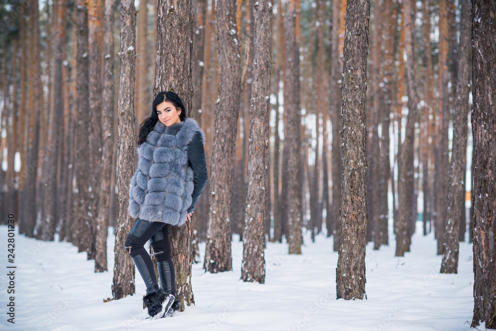 Naklejka premium Elegant and casual female beauty. Attractive lady in grey fur coat, nice girl in park, lifestyle of woman, pretty arabic face 