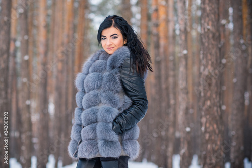 Elegant and casual female beauty. Attractive lady in grey fur coat, nice girl in park, lifestyle of woman, pretty arabic face 