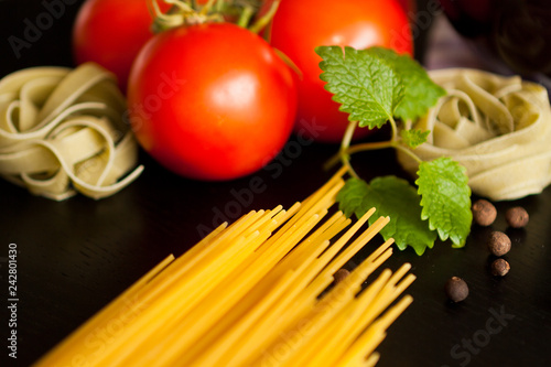 Italian pasta on wood background. Vegetables, pasta and basil. Garlic.