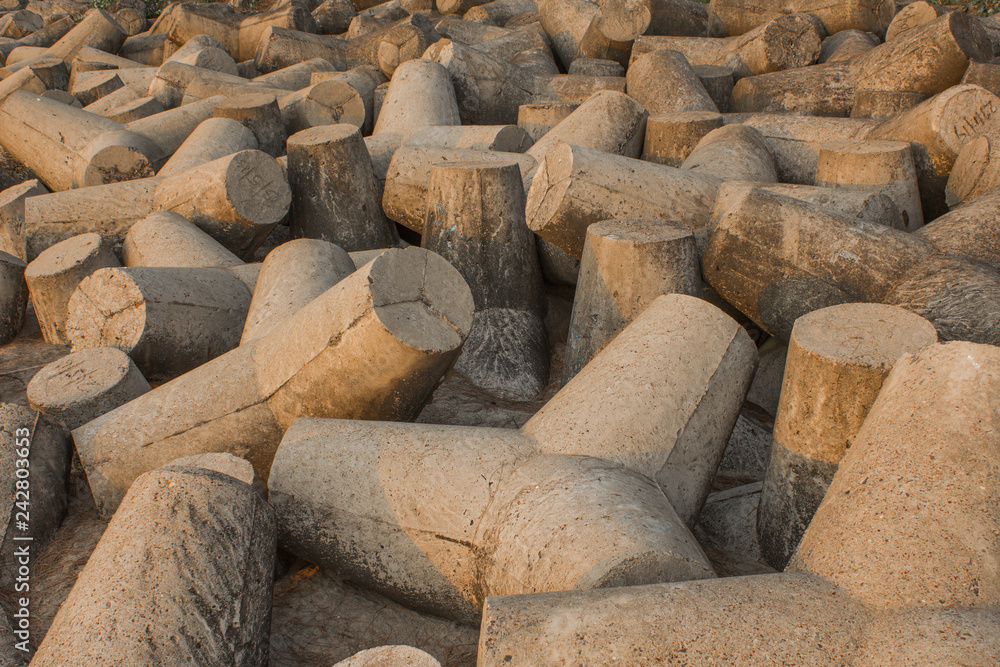 gray concrete tetrapods lie on the sand. tsunami barrier. storm protection