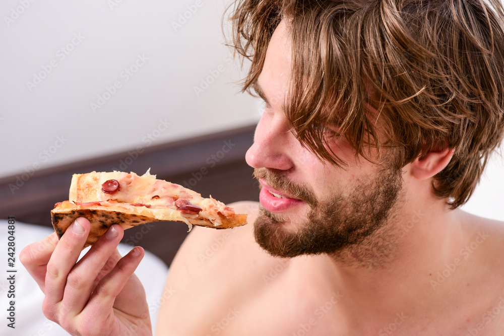 Food delivery service. Sexy man eat pizza lying on bed. Young man resting  at home with a nude and a pizza. Eating pizza in bed. Stock Photo | Adobe  Stock