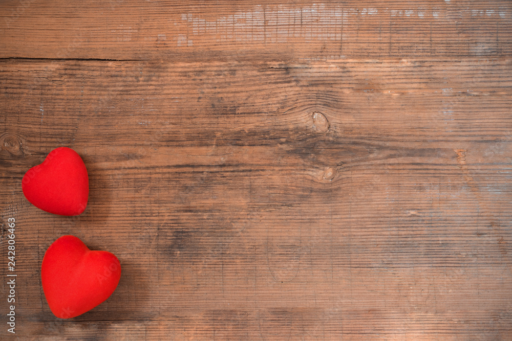Fototapeta premium Pair of red hearts on vintage wooden table top view. Saint Valentines day greeting card.