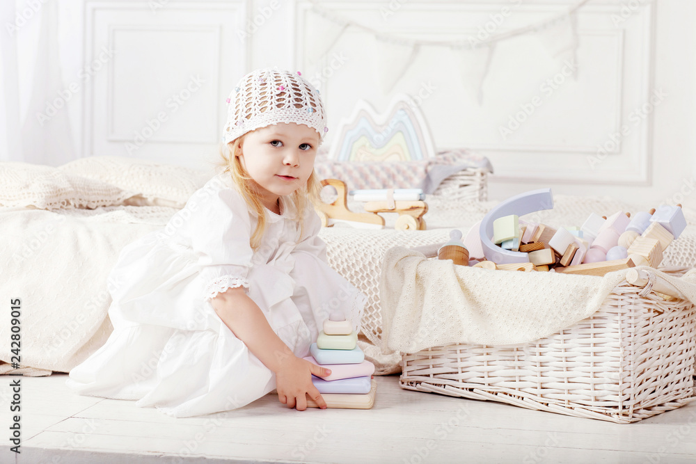 Child girl playing with a wooden toy pyramid. Little cute girl with natural toys. Child girl playing with a wooden toy pyramid. Little cute girl with natural toys.