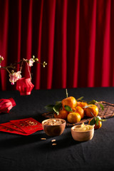 Lunar new year food and drink still life on black background. Translation of text appear in image: Prosperity.