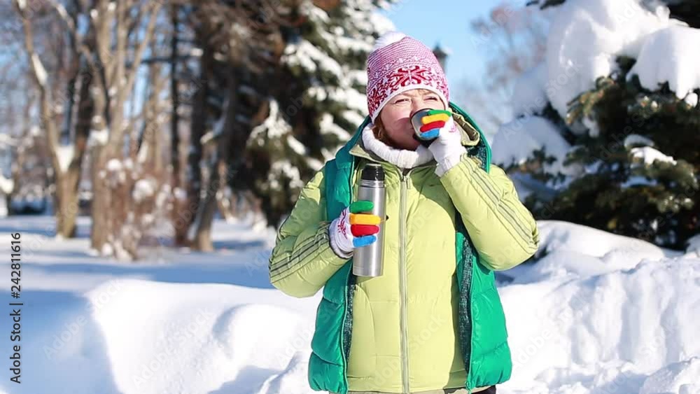 Woman drinking coffee in winter park. Slow motion. Woman drinking coffee in winter park. Slow motion.