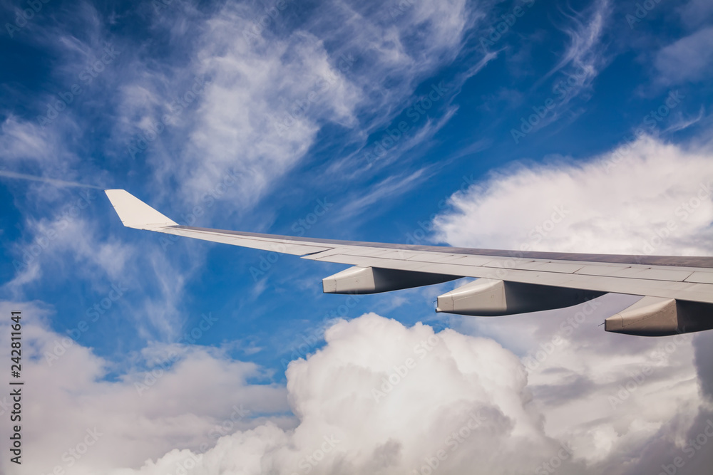 Wing of an airplane flying above the clouds on a clear sunny day. Wing of an airplane flying above the clouds on a clear sunny day.