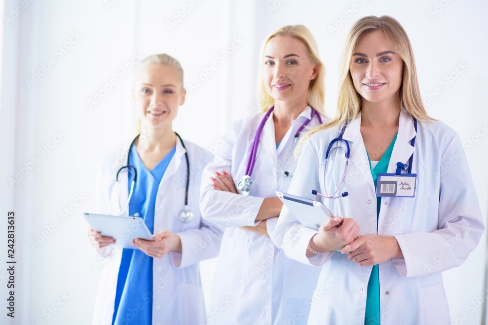 Portrait of three confident female doctors standing with arms crossed at the medical office. Portrait of three confident female doctors standing with arms crossed at the medical office.