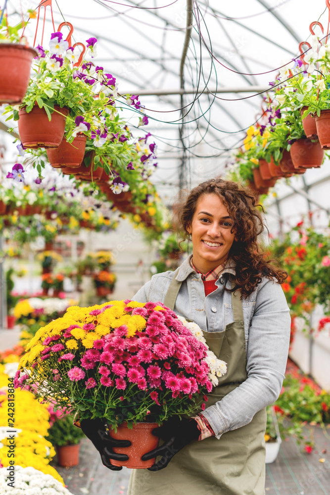 Smiling florist holding pot of flowers