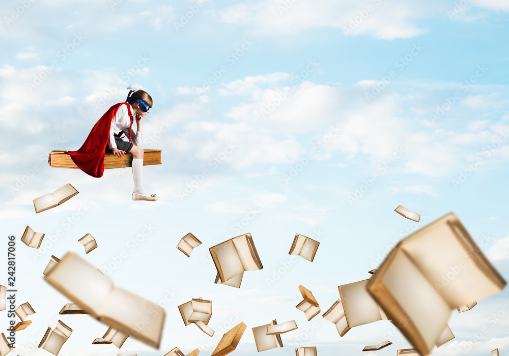 Fototapeta premium Girl power concept with cute kid guardian against cloudscape background