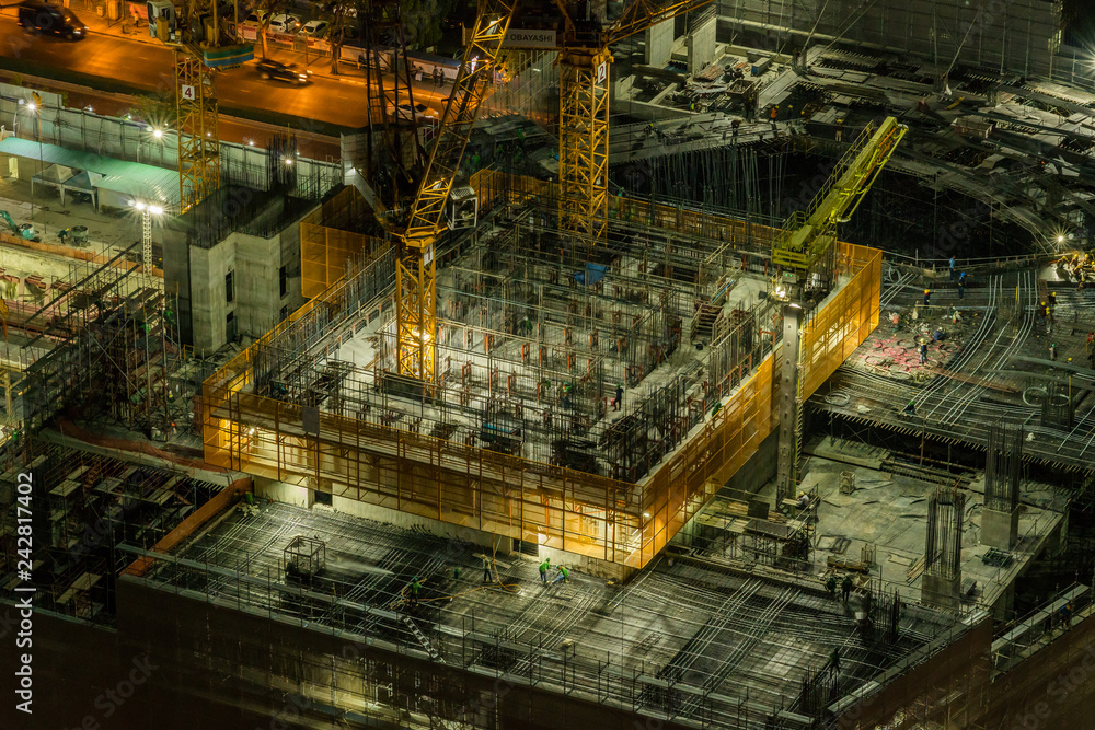 BANGKOK, THAILAND - FEB 2018 : Undefined worker are working in Under construction and Cranes built the building in downtown of bangkok at night time on Febuary 20, 2018. Thailand