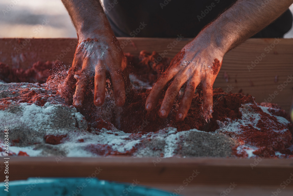 Hands kneading raw meat with spices to make sobrasada