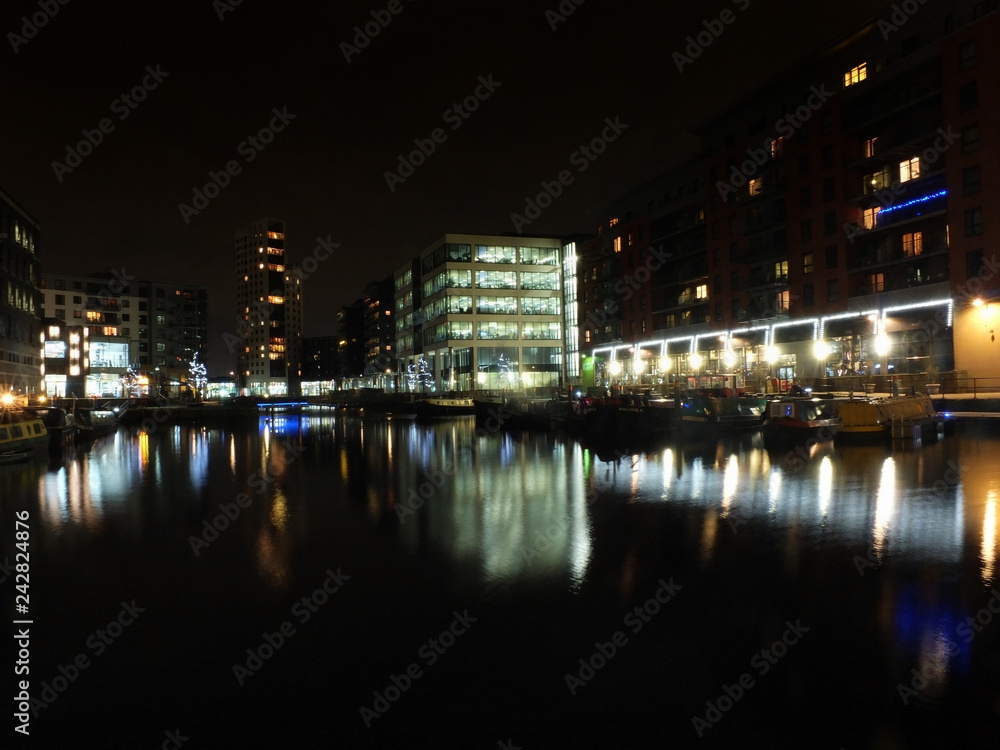 a view of clarence dock in leeds at night with waterside buildings and lights reflected in the water