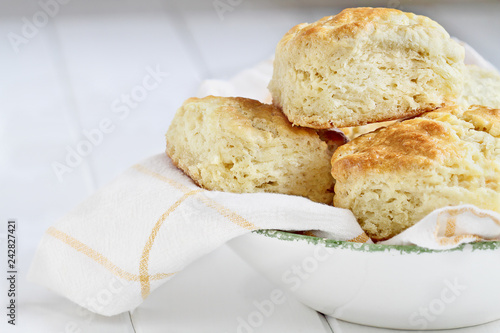 Fresh buttermilk southern biscuits or scones from scratch in a white bowl. photo