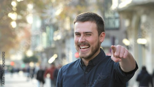 Front view of a happy man pointing at camera smiling