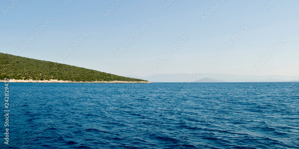 A tranquil island with green vegetation in the sea ocean off of the coast of Turkey