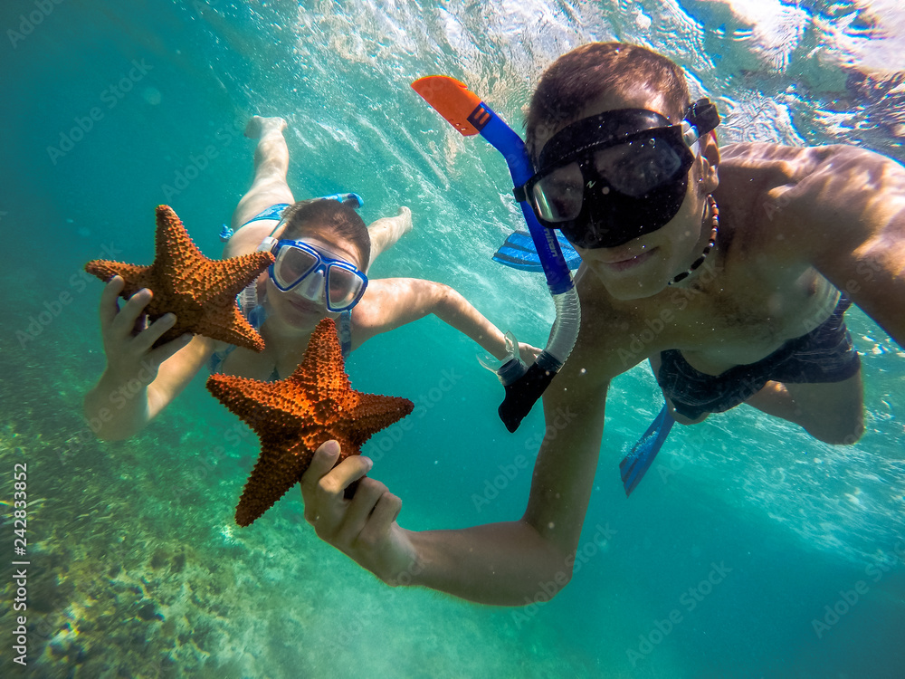 couple snorkeling with starfish 