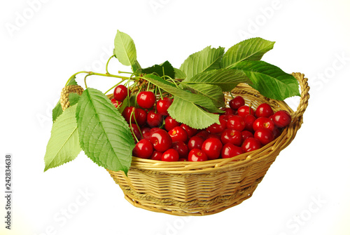 Sweet cherries with leaves in a basket on a white background