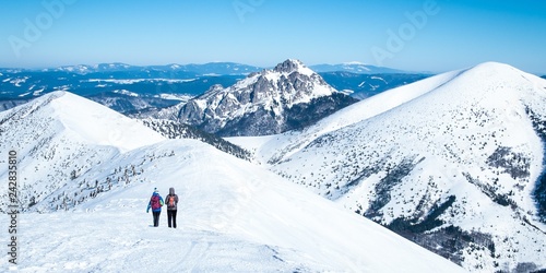 Women on trip in snowy Alps, Alpine tourist area with people, Female tourists on walk European winter mountains