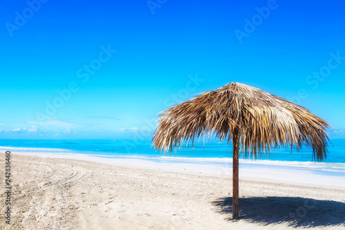 Straw umbrella on empty seaside beach in Varadero  Cuba. Relaxation  vacation idyllic background.