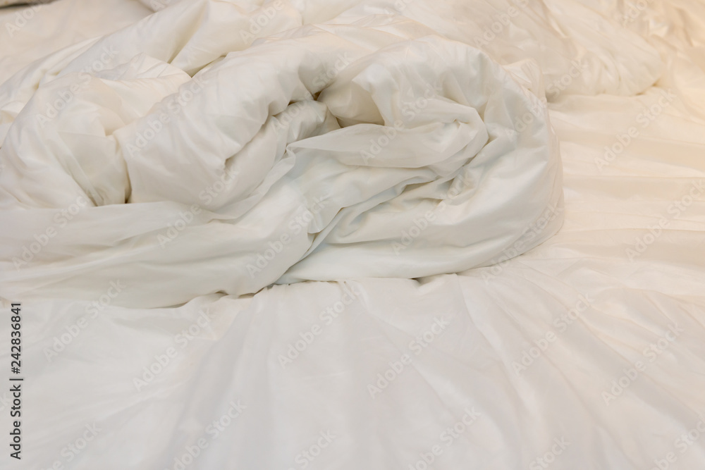 Obraz premium bed in a hotel room with unfolded quilt in the morning