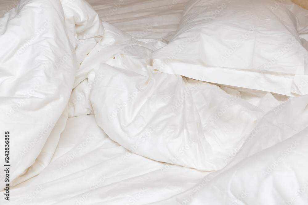 Obraz premium bed in a hotel room with unfolded quilt in the morning